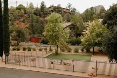 Exterior of building in hills of mountains with groups of trees on lawn near Arabella Hotel Sedona in Sedona, AZ