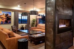 Fireplace in wall near seating area with two tan sofas and glass table near Arabella Hotel Sedona in Sedona, AZ