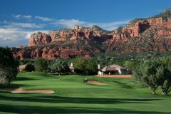 Golf course green with white flag sticking up near sand trap and small house with mountains and trees in background near Arabella Hotel Sedona in Sedona, AZ