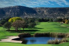 Large pond on golf course with trees  surrounding it as well as a sand bunker and trees and mountains in background near Arabella Hotel Sedona in Sedona, AZ