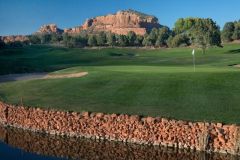 Golf course with white flag sticking up near sand trap and water with mountains and trees in background near Arabella Hotel Sedona in Sedona, AZ