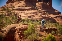 Two people with helmets riding their bikes in the red rocks near the Arabella Hotel in Sedona, AZ.