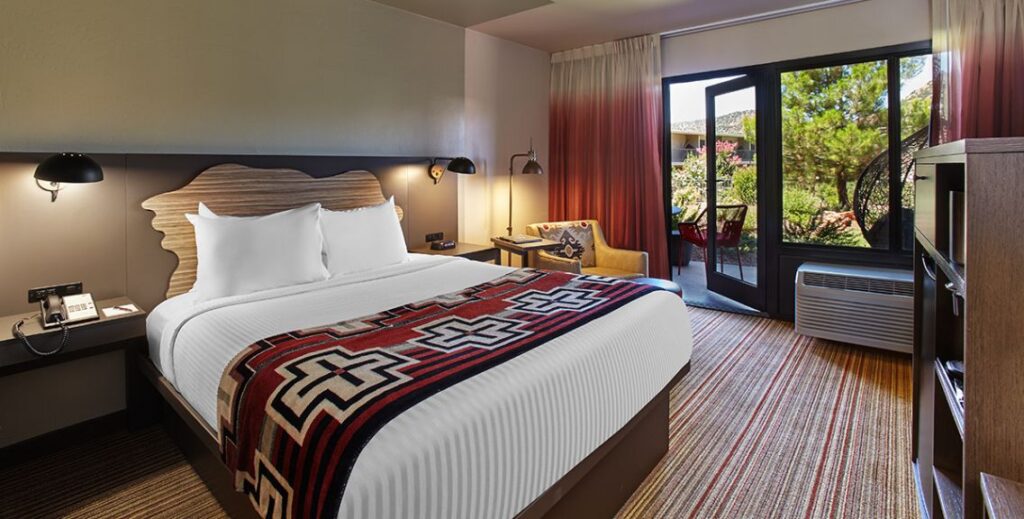 Bedroom with one bed and an outdoor patio with furniture at the Arabella Hotel in Sedona, AZ.
