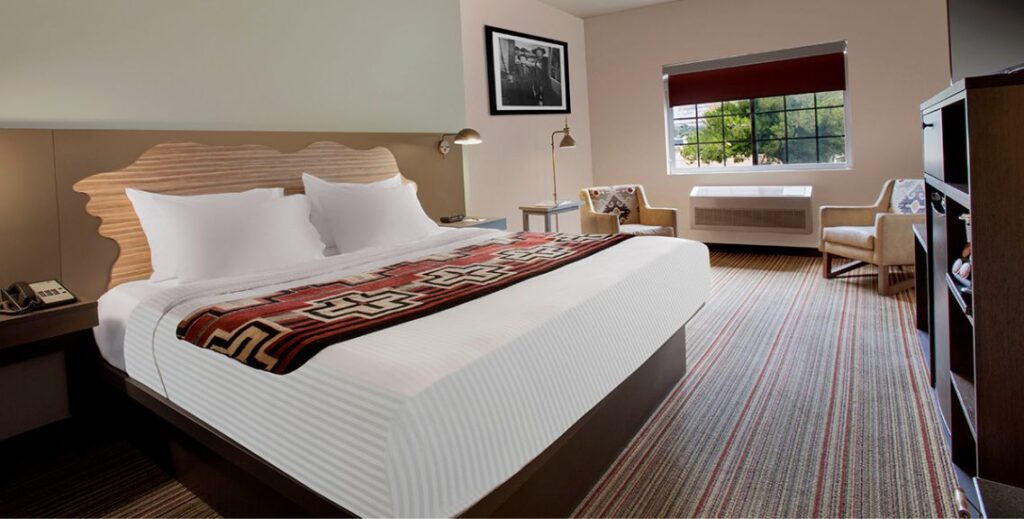 Bedroom with one beds and two chairs at the Arabella Hotel in Sedona, AZ.