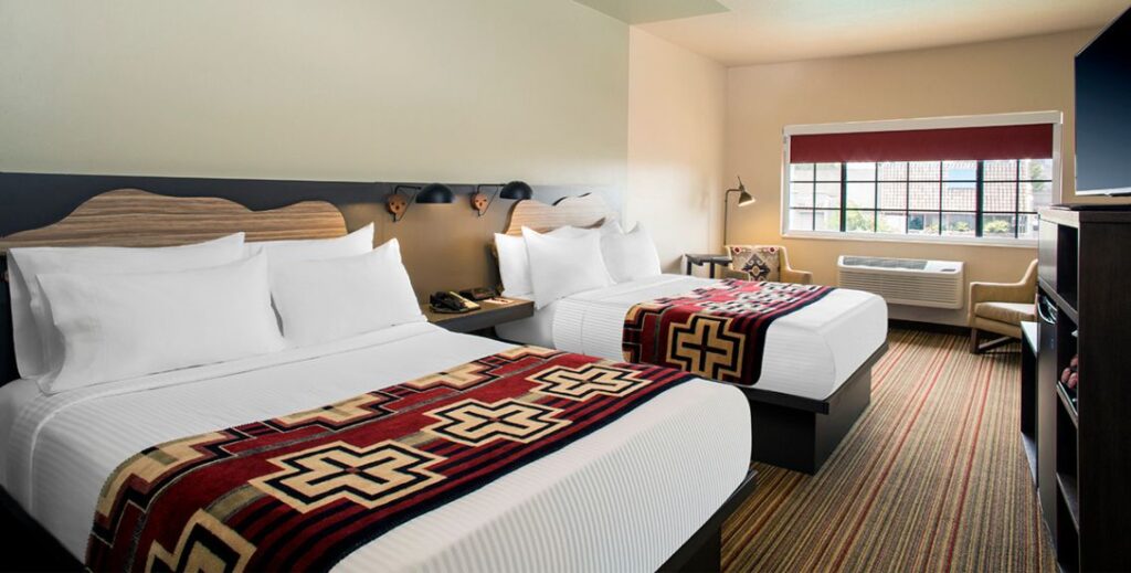 Bedroom with two bed and two chairs at the Arabella Hotel in Sedona, AZ.