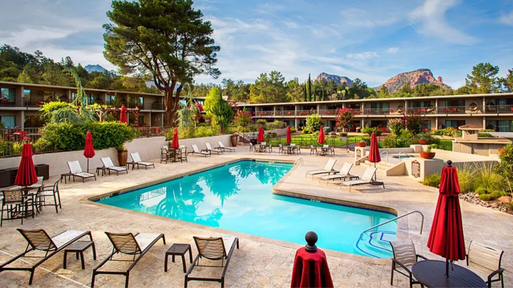 A swimming pool with mountains and red rocks in the background at the Arabella Hotel in Sedona, AZ.