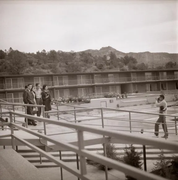 Group of people standing on staircase in front of hotel building with mountains in background while man in front takes a picture at Arabella Hotel Sedona in Sedona, AZ