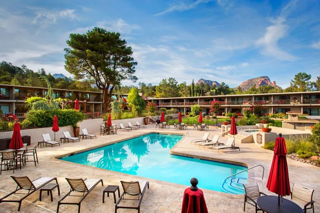 A swimming pool with mountains and red rocks in the background at the Arabella Hotel in Sedona, AZ.